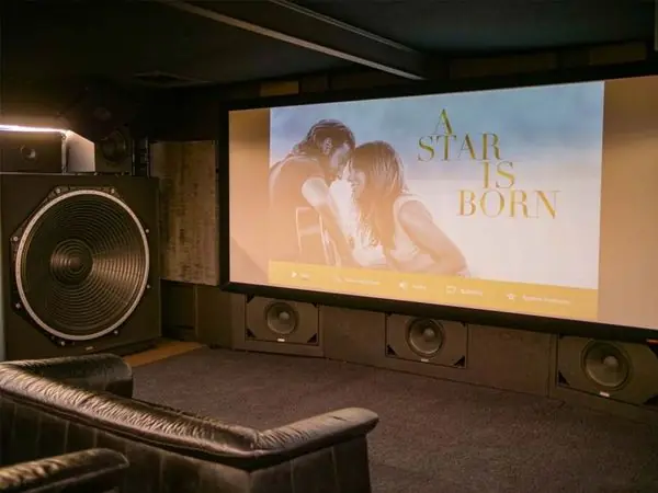 Sala de cine en casa con subwoofer Ascendo junto a la pantalla