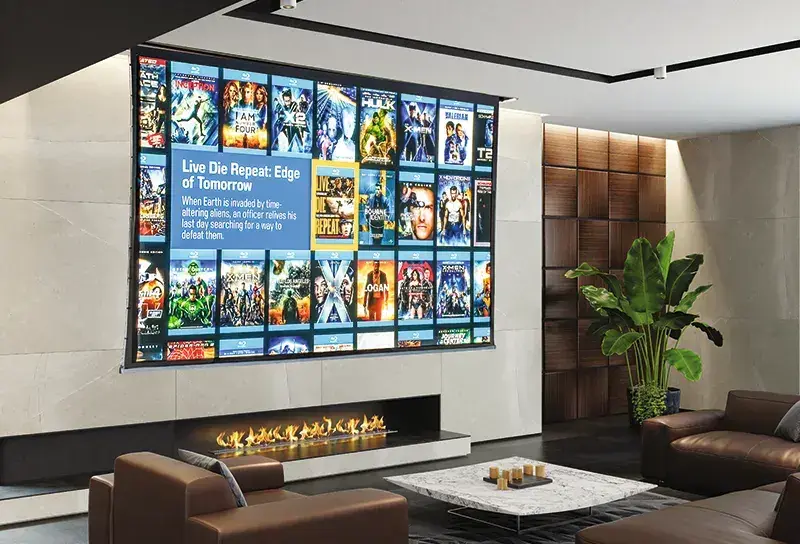 Sala con proyección de gran formato mostrando un catálogo de películas