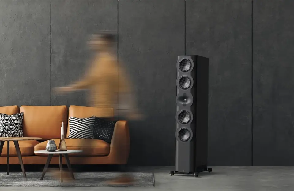 Bocina de torre Perlisten en una sala con sofá de piel