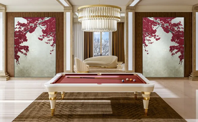 Mesa de billar Regis de Vismara Design, lacada en marfil con paño rojo y patas cónicas con anillos dorados, al centro de un salón clásico bajo un candil de cristal.