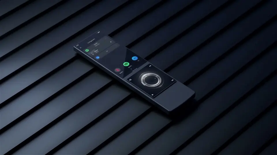 Control AVA Cinema Remote sobre una superficie de franjas oscuras: pantalla táctil con accesos a Spotify, Netflix y TV y, abajo, la rueda táctil iluminada.