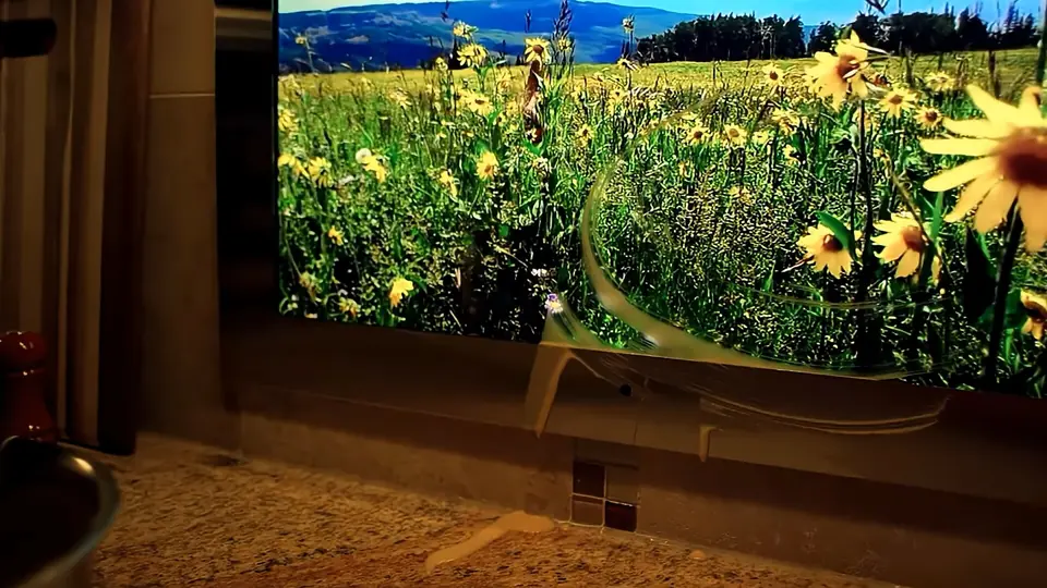Espejo con pantalla Séura en un baño de piedra, mostrando un campo de flores amarillas.