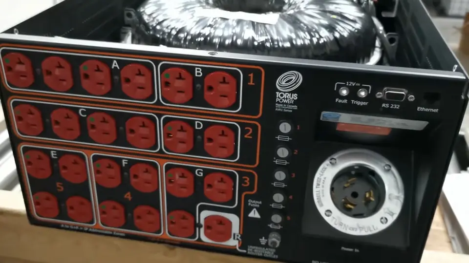 Acondicionador de energía Torus Power abierto: arriba, el transformador toroidal; al frente, el panel de contactos rojos agrupados por zonas y el conector de entrada.