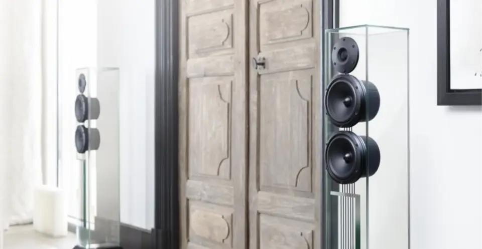 Bocinas de cristal Waterfall Audio frente a unas puertas de madera antiguas
